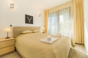 a bedroom with a bed with two towels on it at Nature Retreat 2 bedroom apartment Silver Mountain in Poiana Brasov +39 photos