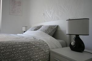 sypialnia z łóżkiem i lampką na szafce nocnej w obiekcie Apartments Mali Nono w Krku