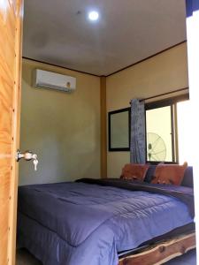a bedroom with a large bed with a window at Baan Panseng Bungalow in Ko Kood