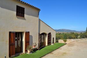 Biały dom z ogródkiem z zieloną trawą w obiekcie 081 Finca Els Tarongers ETV5766 by Mallorca Charme w mieście Muro