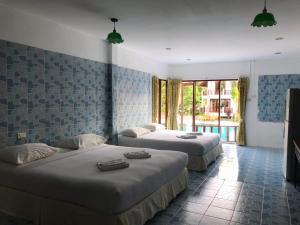 a hotel room with two beds and a window at Koh Chang Thai Garden Hill Resort in Ko Chang