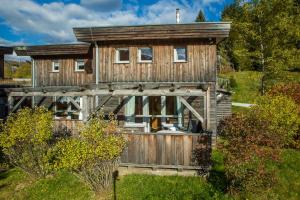 a wooden house with a fence and trees at Feriendorf Tauerngast in Hohentauern