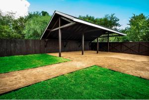 a pavilion with a black roof and green grass at Beautiful Guest House on New Built Home Near Downtown in San Antonio