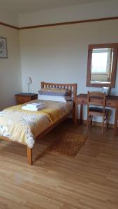 Kilcreeny Lodge في ليسبرن: غرفة نوم بسرير ومكتب وكرسي