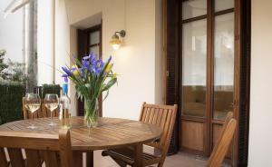 einen Holztisch mit einer Vase aus Blumen und Weingläsern in der Unterkunft Santa Clara by Oldtown Apartments in San Sebastián