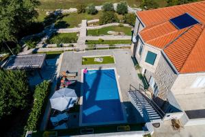 een uitzicht over een huis met een zwembad en een oranje dak bij Villa Oasis Cypress in Čilipi