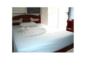 a large white bed with a flower on top of it at Hotel Brasil Real in Mariana