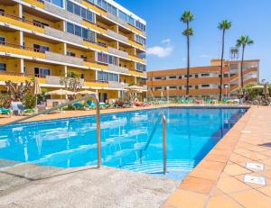 una piscina frente a un edificio de apartamentos en Apartamentos Los Tilos, en Playa del Inglés