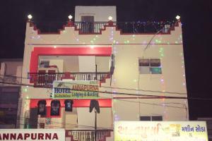 a tall white building with christmas lights on it at Annapurna in Sasan Gir