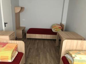 a small room with two beds and a table at Hostel Laurita in Kaunas