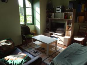 - un salon avec un canapé et une table dans l'établissement Logis de la Provosterie - CYCLAMEN, à Ahuillé
