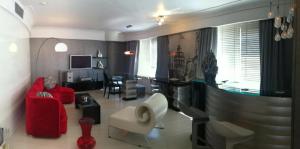 a living room with red chairs and a dining room at Surmeli Istanbul Hotel in Istanbul
