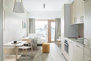 Habitación blanca con cama, mesa y sillas en Noli Katajanokka en Helsinki