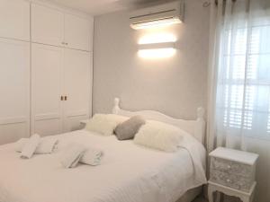 a white bedroom with a white bed with pillows at La Caleta Luxury Seaside Villa with 3 Bedrooms and Private Pool in Adeje +99 photos