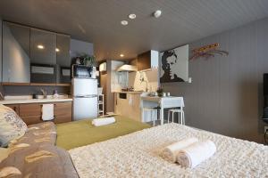 a room with a kitchen and a bed with towels at Akabane TK Building 102 in Tokyo