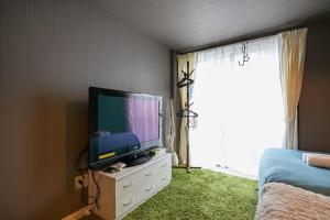 a bedroom with a television on a dresser with a window at Akabane TK Building 102 in Tokyo