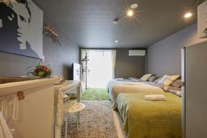 a room with two beds and a kitchen with a sink at Akabane TK Building 102 in Tokyo
