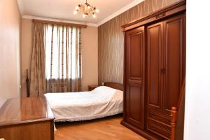a bedroom with a bed and a wooden cabinet at Cascade Residence in Yerevan