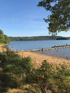 a beach with people on a dock in the water at Alingsås Golfklubb in Alingsås