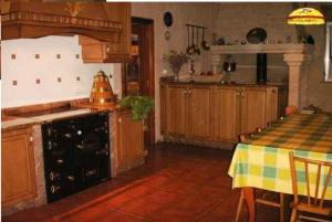 a kitchen with a table and a stove top oven at Casa Jesús Turismo Rural in Lires