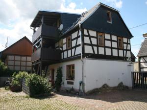a white and black house with a black roof at Pferd - Spaß - Entspannung in Staitz