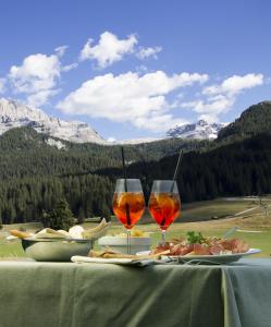 stół z dwoma kieliszkami wina i jedzeniem w obiekcie Hotel Casa del Campo w Madonna di Campiglio