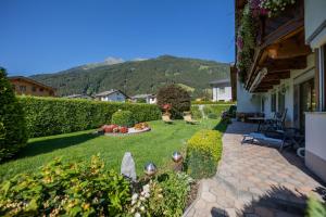 a backyard with a garden with a lawn and a house at Haus Egger in Neustift im Stubaital