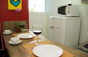 a table with two glasses of wine and a microwave at Pousada das Estrelas in Florianópolis