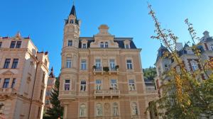 un edificio con una torre de reloj encima en Apartment Themis, en Karlovy Vary