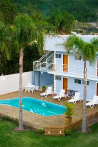 una casa con piscina y 2 palmeras en Pousada das Estrelas, en Florianópolis