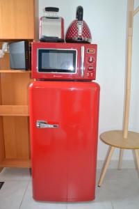 a microwave sitting on top of a red refrigerator at Tiny Bikini, Ault, Baie de Somme, 200 m de la mer in Ault