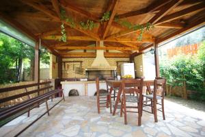 a wooden pavilion with a table and chairs and a stove at Villa Dimitra Nikiana in Nikiana