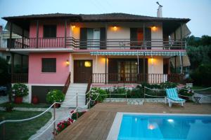 a house with a swimming pool in front of it at Villa Dimitra Nikiana in Nikiana