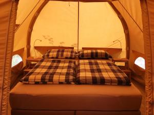 a bed in a tent with two pillows on it at Agriturismo Unico Senso - Glamping in Montottone
