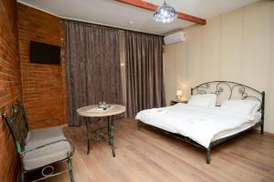 una camera da letto con un letto, un tavolo e una TV di Hotel Ragnar a Nizhnyaya Alekseyevka