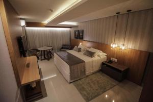 ポルト・ヴェーリョにあるOscar Hotel Executiveのベッド、テーブル、テレビが備わるホテルルームです。