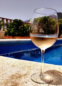 a glass of wine sitting on a table next to a pool at Casas Balcón del Mar in El Paso