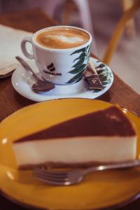 un trozo de pastel en un plato con una taza de café en Casa Jesús Turismo Rural en Lires