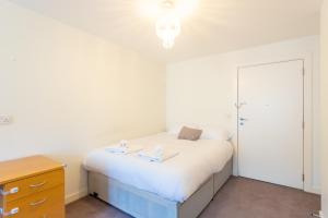 a bedroom with a bed and a dresser with two plates on it at Amazing Modern 2 Bedroom Flat in Greenwich for 4 people in London