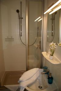 y baño con ducha, lavamanos y ducha. en Romagna Mia - Hotel Ristorante Pizzeria, en Nersingen