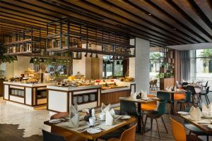 a restaurant with tables and chairs and a kitchen at Millennium Al Barsha in Dubai