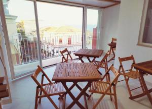 eine Gruppe von Tischen und Stühlen auf einem Balkon in der Unterkunft Hello B&B in Acitrezza