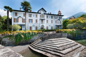 a large white house with a staircase in front of it at Miralago Apartments Villa Trotti in Bellagio