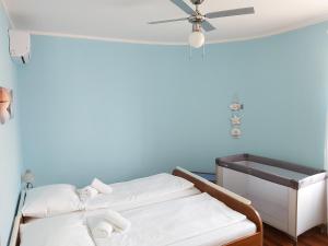 Zimmer mit 2 Betten und einem Deckenventilator in der Unterkunft Apartment Nika, 4*, 2-bedroom, barbecue in Baška