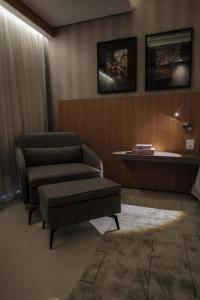 uma sala de estar com um sofá e uma cadeira em Oscar Hotel Executive em Porto Velho