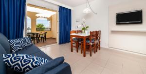 a living room with a couch and a table at Globales Binimar in Cala en Blanes