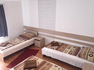 a room with two beds and a rug at Gerendas Panzió in Szombathely