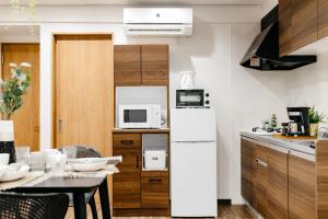 a kitchen with a white refrigerator and a table at Ikoi in Osaka