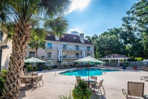 a hotel with a palm tree and a swimming pool at Palmera Inn and Suites in Hilton Head Island