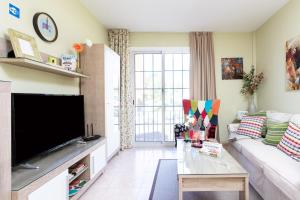 Una sala de estar con un televisor de pantalla plana grande. en Vivienda Vacacional La Laguna Deluxe 1, en La Laguna